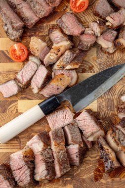 Kesme tahtasındaki biftek, otlar ve baharatlarla. Ahşap tahtada ızgara sebzelerle ızgara sığır filetosu. Filet Mignon tarif konsepti, seçici odaklanma