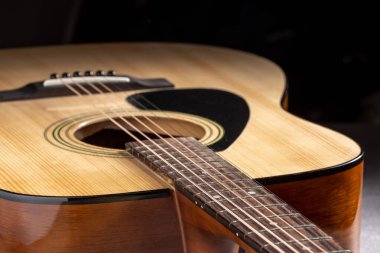 Klasik gitar, yakın çekim. Ahşap arka planda akustik gitar. Müzik aleti konsepti.