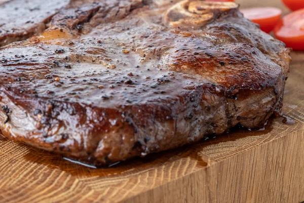 Kesme tahtasındaki biftek, otlar ve baharatlarla. Ahşap tahtada ızgara sebzelerle ızgara sığır filetosu. Filet Mignon tarif konsepti, seçici odaklanma
