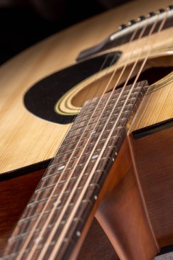 Klasik gitar, yakın çekim. Ahşap arka planda akustik gitar. Müzik aleti konsepti.