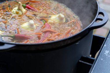 Dev bir kazanda gerçek Özbek pilavı. Özbekistan 'da milli yemekleri pişirmek. Kazanda etli pilav var. Geleneksel pilav pişirme