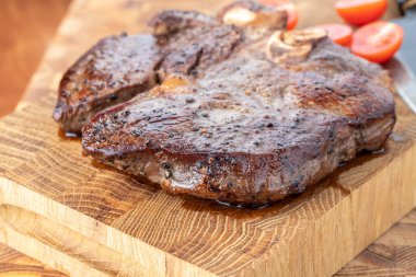 Kesme tahtasındaki biftek, otlar ve baharatlarla. Ahşap tahtada ızgara sebzelerle ızgara sığır filetosu. Filet Mignon tarif konsepti, seçici odaklanma