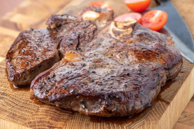 Kesme tahtasındaki biftek, otlar ve baharatlarla. Ahşap tahtada ızgara sebzelerle ızgara sığır filetosu. Filet Mignon tarif konsepti, seçici odaklanma