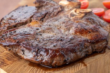Kesme tahtasındaki biftek, otlar ve baharatlarla. Ahşap tahtada ızgara sebzelerle ızgara sığır filetosu. Filet Mignon tarif konsepti, seçici odaklanma