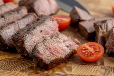 Kesme tahtasındaki biftek, otlar ve baharatlarla. Ahşap tahtada ızgara sebzelerle ızgara sığır filetosu. Filet Mignon tarif konsepti, seçici odaklanma