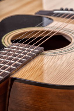 Klasik gitar, yakın çekim. Ahşap arka planda akustik gitar. Müzik aleti konsepti.