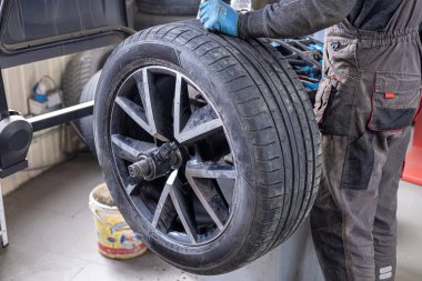 Lastik servisi. Sıkıştırılmış hava aracı. Arabanın lastiklerini değiştirmek, araba tamirciliği, yeni lastik değiştirme işlemi, garajda araba freni tamiri..