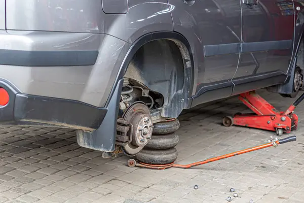 轮胎服务 压缩空气工具 汽车修理工 在新的轮胎更换过程中 汽车制动器在车库里修理 — 图库照片#
