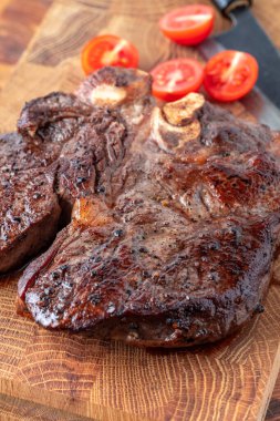 Kesme tahtasındaki biftek, otlar ve baharatlarla. Ahşap tahtada ızgara sebzelerle ızgara sığır filetosu. Filet Mignon tarif konsepti, seçici odaklanma