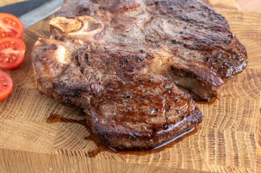 Kesme tahtasındaki biftek, otlar ve baharatlarla. Ahşap tahtada ızgara sebzelerle ızgara sığır filetosu. Filet Mignon tarif konsepti, seçici odaklanma