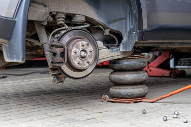 Lastik servisi. Sıkıştırılmış hava aracı. Arabanın lastiklerini değiştirmek, araba tamirciliği, yeni lastik değiştirme işlemi, garajda araba freni tamiri..