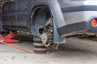 Lastik servisi. Sıkıştırılmış hava aracı. Arabanın lastiklerini değiştirmek, araba tamirciliği, yeni lastik değiştirme işlemi, garajda araba freni tamiri..