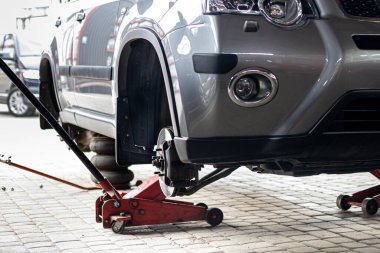 Lastik servisi. Sıkıştırılmış hava aracı. Arabanın lastiklerini değiştirmek, araba tamirciliği, yeni lastik değiştirme işlemi, garajda araba freni tamiri..