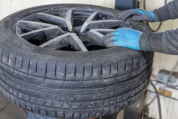 Tyre service. Compressed air tool. Changing the tyres on the car, car service.Auto mechanic,in process of new tire replacement, Car brake repairing in garage.