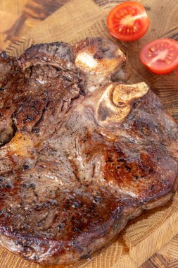 Kesme tahtasındaki biftek, otlar ve baharatlarla. Ahşap tahtada ızgara sebzelerle ızgara sığır filetosu. Filet Mignon tarif konsepti, seçici odaklanma