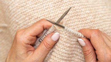 Yün ipliği kullanarak telli el yapımı giysiler ören tanınmamış bir kadının ellerine yakın durun. Boş zaman etkinliği kavramı. İplikten örgü örmek..