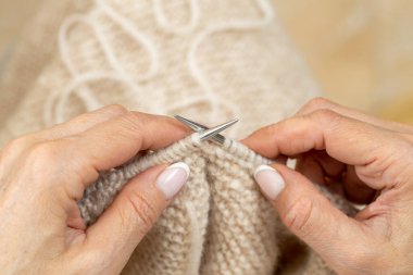 Yün ipliği kullanarak telli el yapımı giysiler ören tanınmamış bir kadının ellerine yakın durun. Boş zaman etkinliği kavramı. İplikten örgü örmek..