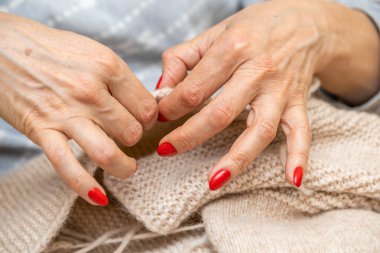 Yün ipliği kullanarak telli el yapımı giysiler ören tanınmamış bir kadının ellerine yakın durun. Boş zaman etkinliği kavramı. İplikten örgü örmek..