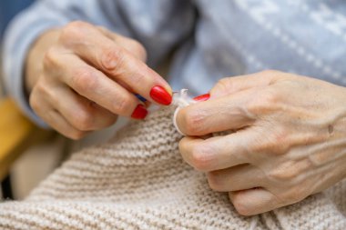 Yün ipliği kullanarak telli el yapımı giysiler ören tanınmamış bir kadının ellerine yakın durun. Boş zaman etkinliği kavramı. İplikten örgü örmek..