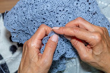 Yün ipliği kullanarak telli el yapımı giysiler ören tanınmamış bir kadının ellerine yakın durun. Boş zaman etkinliği kavramı. İplikten örgü örmek..