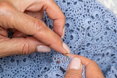 Yün ipliği kullanarak telli el yapımı giysiler ören tanınmamış bir kadının ellerine yakın durun. Boş zaman etkinliği kavramı. İplikten örgü örmek..