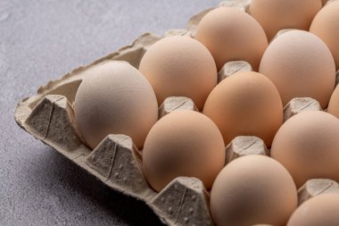 Sıraya dizilmiş kahverengi yumurtalar. Karton kasette bir grup taze beyaz yumurta. Doğadan gelen organik gıdalar sağlık için iyidir..