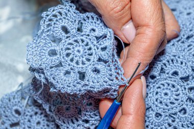 Yün ipliği kullanarak telli el yapımı giysiler ören tanınmamış bir kadının ellerine yakın durun. Boş zaman etkinliği kavramı. İplikten örgü örmek..