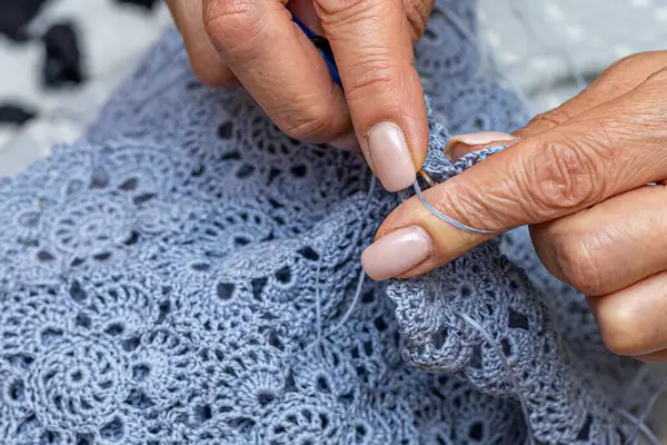 Yün ipliği kullanarak telli el yapımı giysiler ören tanınmamış bir kadının ellerine yakın durun. Boş zaman etkinliği kavramı. İplikten örgü örmek..