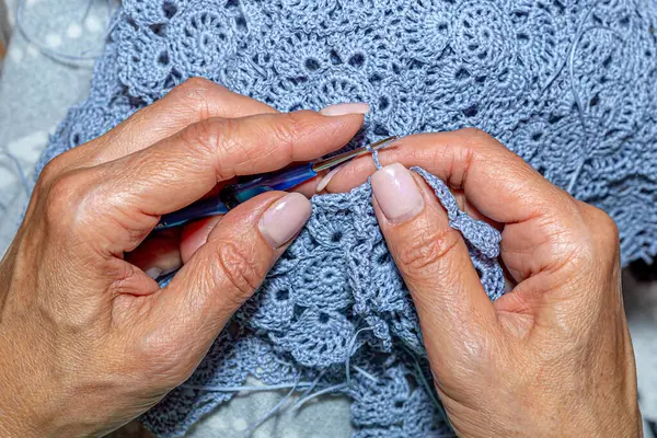 Yün ipliği kullanarak telli el yapımı giysiler ören tanınmamış bir kadının ellerine yakın durun. Boş zaman etkinliği kavramı. İplikten örgü örmek..