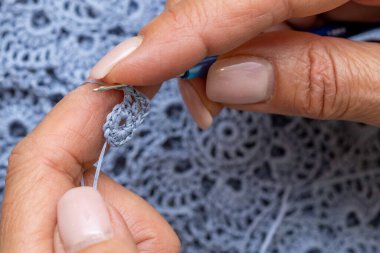 Yün ipliği kullanarak telli el yapımı giysiler ören tanınmamış bir kadının ellerine yakın durun. Boş zaman etkinliği kavramı. İplikten örgü örmek..