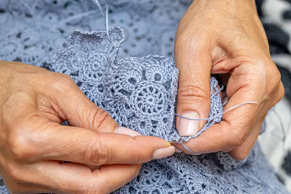 Yün ipliği kullanarak telli el yapımı giysiler ören tanınmamış bir kadının ellerine yakın durun. Boş zaman etkinliği kavramı. İplikten örgü örmek..