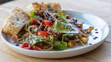 Et salatası, pastırma, yumurta, kızarmış ekmek, marul, salata sosu salata salatası salatanın arka planı kırsal alan manzarası