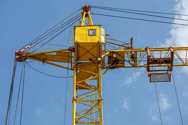 İnşaat halindeki yüksek bina, iskeleli vinç, bir inşaat alanında Freestanding kulesi. Mavi gökyüzüne karşı inşaat alanı çalışması.