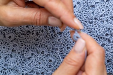 Yün ipliği kullanarak telli el yapımı giysiler ören tanınmamış bir kadının ellerine yakın durun. Boş zaman etkinliği kavramı. İplikten örgü örmek..