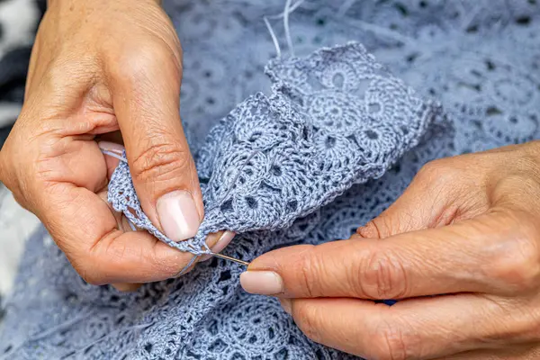 Yün ipliği kullanarak telli el yapımı giysiler ören tanınmamış bir kadının ellerine yakın durun. Boş zaman etkinliği kavramı. İplikten örgü örmek..