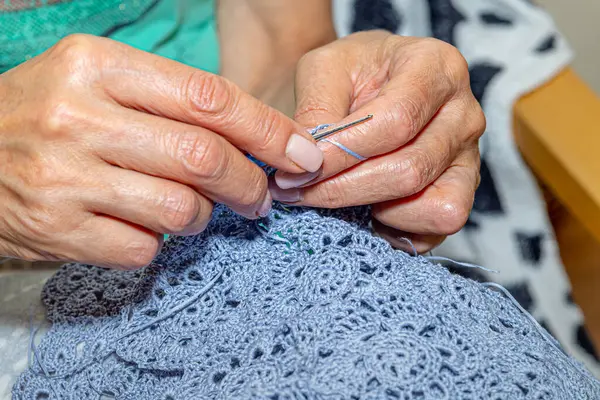 Yün ipliği kullanarak telli el yapımı giysiler ören tanınmamış bir kadının ellerine yakın durun. Boş zaman etkinliği kavramı. İplikten örgü örmek..