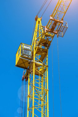 İnşaat halindeki yüksek bina, iskeleli vinç, bir inşaat alanında Freestanding kulesi. Mavi gökyüzüne karşı inşaat alanı çalışması.