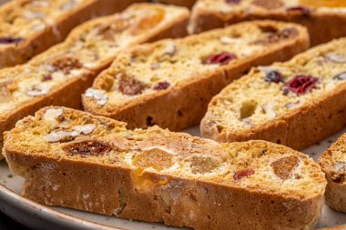 İtalyan bademli bisküvileri kırsal bir evde yapılmış çömlek kasesinde. Badem ve yaban mersiniyle süslenmiş bu iki kez pişirilmiş ikramlar aromatik ve davetkar. İdeal.