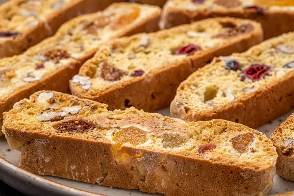 İtalyan bademli bisküvileri kırsal bir evde yapılmış çömlek kasesinde. Badem ve yaban mersiniyle süslenmiş bu iki kez pişirilmiş ikramlar aromatik ve davetkar. İdeal.