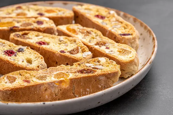 İtalyan bademli bisküvileri kırsal bir evde yapılmış çömlek kasesinde. Badem ve yaban mersiniyle süslenmiş bu iki kez pişirilmiş ikramlar aromatik ve davetkar. İdeal.