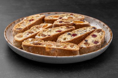 İtalyan bademli bisküvileri kırsal bir evde yapılmış çömlek kasesinde. Badem ve yaban mersiniyle süslenmiş bu iki kez pişirilmiş ikramlar aromatik ve davetkar. İdeal.