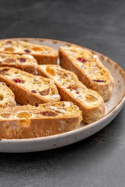 İtalyan bademli bisküvileri kırsal bir evde yapılmış çömlek kasesinde. Badem ve yaban mersiniyle süslenmiş bu iki kez pişirilmiş ikramlar aromatik ve davetkar. İdeal.