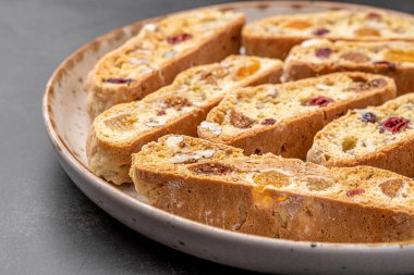 İtalyan bademli bisküvileri kırsal bir evde yapılmış çömlek kasesinde. Badem ve yaban mersiniyle süslenmiş bu iki kez pişirilmiş ikramlar aromatik ve davetkar. İdeal.