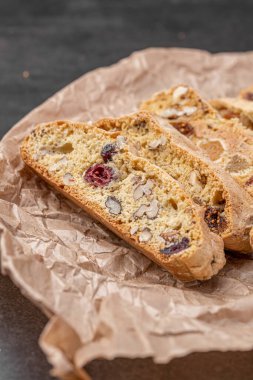 İtalyan bademli bisküvileri kırsal bir evde yapılmış çömlek kasesinde. Badem ve yaban mersiniyle süslenmiş bu iki kez pişirilmiş ikramlar aromatik ve davetkar. İdeal.