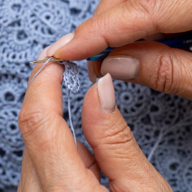 Yün ipliği kullanarak telli el yapımı giysiler ören tanınmamış bir kadının ellerine yakın durun. Boş zaman etkinliği kavramı. İplikten örgü örmek..