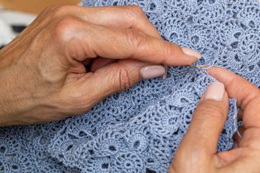 Yün ipliği kullanarak telli el yapımı giysiler ören tanınmamış bir kadının ellerine yakın durun. Boş zaman etkinliği kavramı. İplikten örgü örmek..