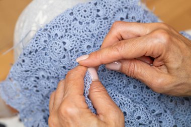 Yün ipliği kullanarak telli el yapımı giysiler ören tanınmamış bir kadının ellerine yakın durun. Boş zaman etkinliği kavramı. İplikten örgü örmek..