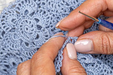 Yün ipliği kullanarak telli el yapımı giysiler ören tanınmamış bir kadının ellerine yakın durun. Boş zaman etkinliği kavramı. İplikten örgü örmek..