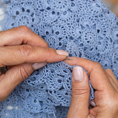 Yün ipliği kullanarak telli el yapımı giysiler ören tanınmamış bir kadının ellerine yakın durun. Boş zaman etkinliği kavramı. İplikten örgü örmek..