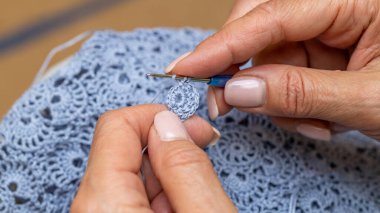 Yün ipliği kullanarak telli el yapımı giysiler ören tanınmamış bir kadının ellerine yakın durun. Boş zaman etkinliği kavramı. İplikten örgü örmek..